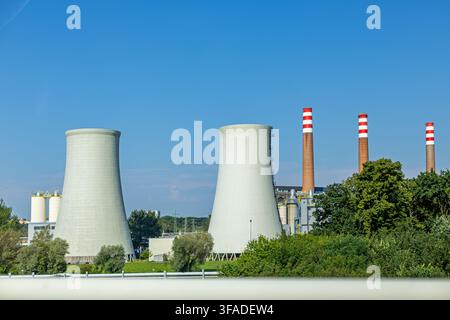 Paysage industriel avec de grandes tours de refroidissement et des cheminées d'une centrale thermique sous un ciel bleu clair. Installation de production d'énergie par cogénération, énergie propre Banque D'Images