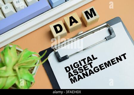 Concept de DAM - Gestion des actifs numériques écrit sur un tableau isolé sur une table. Banque D'Images