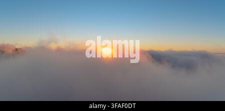 Vue aérienne époustouflante du soleil se couchant sur une couche dense de nuages et de brouillard dans les montagnes de Dahu, comté de Miaoli, à Taïwan. Banque D'Images