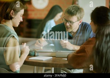 Des étudiants divers étudiant ensemble à la bibliothèque du campus universitaire Banque D'Images
