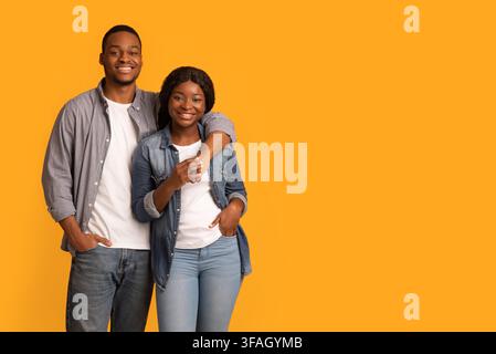 Portrait d'un couple noir souriant et joyeux qui embrasse et sourit à l'appareil photo Banque D'Images