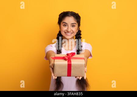 Bonne femme indienne tenant la boîte cadeau et donnant à l'appareil photo Banque D'Images