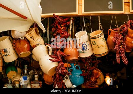 Des pots en céramique traditionnels et des poivrons séchés Capsicum annuum décorent un étal de marché méditerranéen. Concept d’héritage, de cuisine, d’artisanat, de voyage Banque D'Images