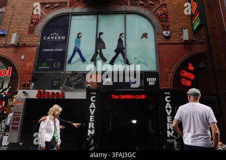 L'entrée de l'emblématique Cavern Club sur Mathew Street avec un grand graphisme Beatles style Abbey Road et des piétons à Liverpool, Royaume-Uni Banque D'Images