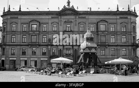 Photo en noir et blanc de clients se détendant à l'extérieur du Cafe Pavilion, un kiosque emblématique datant de 1913, autrefois un kiosque à journaux transformé en kiosque à café à Kongens Nytorv, Copenhague. Banque D'Images