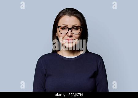 Portrait rapproché d'une femme mûre souriante dans la quarantaine avec des lunettes, prise en studio Banque D'Images