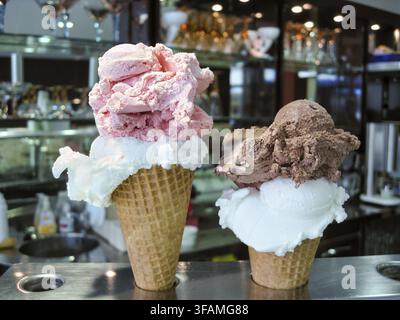 Deux cônes de glace croustillants, cônes gaufrés avec deux grosses boules de glace crémeuse, différents parfums, fraise, chocolat, citron, italien traditionnel Banque D'Images