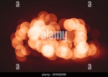 Fond abstrait avec des lumières bokeh dorées chaudes créant une atmosphère douce et magique festive. Banque D'Images