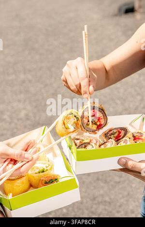 Amis partageant différentes sortes de rouleaux de sushi Banque D'Images