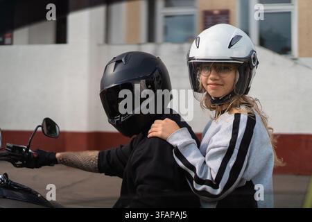 Jeune femme en tant que passagère sur une moto Banque D'Images