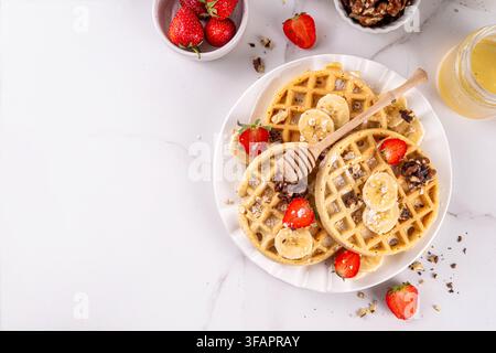 Gaufres saines d'avoine banane sans gluten avec ingrédient pour la cuisine, banane fraîche, tranches de fraises, noix et miel. Recette de gaufres belges maison Banque D'Images
