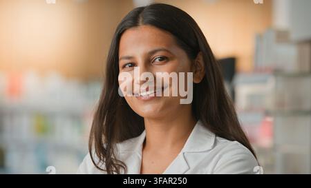 Close-up d'une femme arabe heureuse souriante, femme ethnique hindoue, jeune fille joyeuse souriant à l'objectif dans une pharmacie de clinique, portrait d'un médecin indien, soins de santé Banque D'Images