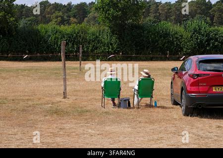 personnes assises sur des sièges dans un parking à Sheringham, Norfolk, Angleterre Banque D'Images