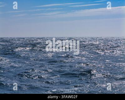 Des vagues scintillantes poussées par le vent s'étendent sur la mer du Nord au large des Shetland, au Royaume-Uni, sous un ciel bleu éclatant Banque D'Images