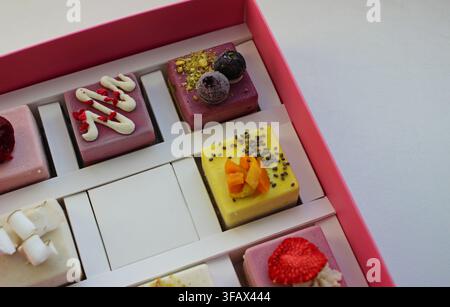 Différentes variantes de gâteaux à base de nougat, de noix et de fruits. Desserts pour végétaliens dans une boîte à gâteaux Banque D'Images