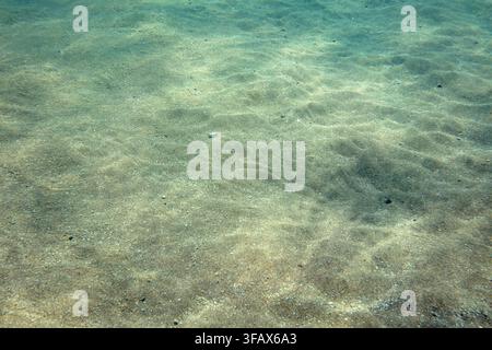 Photo sous-marine, fond marin peu profond vu du haut, réfraction de la lumière faisant des éblouissements arc-en-ciel sur le sable. Fond marin abstrait Banque D'Images