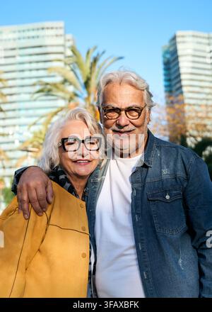 Couple de personnes âgées heureux prenant un selfie ensemble dans un parc urbain ensoleillé Banque D'Images