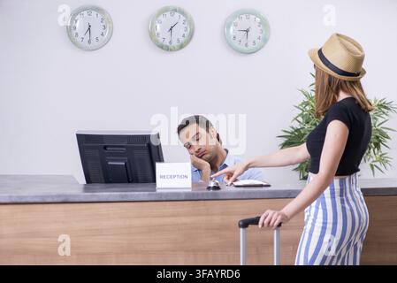 La jeune femme à la réception de l'hôtel Banque D'Images