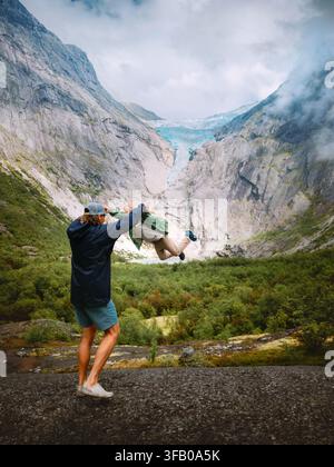 Père et fille s'amusent lors de voyages en montagne ensemble en Norvège, vacances en famille en plein air, parent et enfant jouant et profitant du glacier de Briksdalsbreen Banque D'Images
