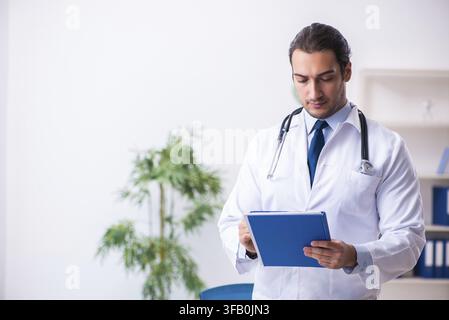 Beau jeune médecin travaillant en clinique Banque D'Images