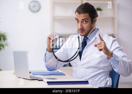 Beau jeune médecin travaillant en clinique Banque D'Images