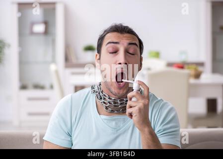 Jeune homme souffre d'un mal de gorge à la maison Banque D'Images