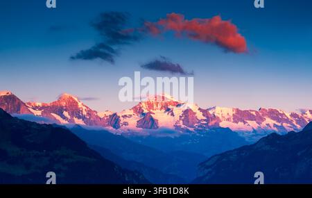 Aube panoramique avec lueur des Alpes sur les sommets enneigés des glaciers du Haut-Valais, Alpes suisses, Suisse. Paysage de nature sauvage paisible à l’aube Banque D'Images