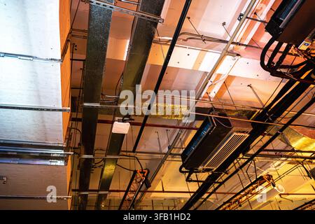 Plafond industriel avec tuyaux et conduits exposés. Banque D'Images