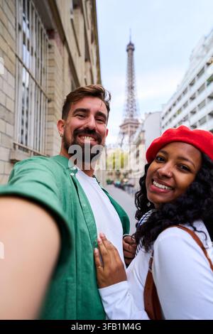 Couple heureux prenant un selfie près de la tour Eiffel à Paris. Banque D'Images