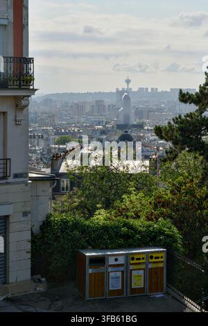 Vue panoramique sur les toits de Paris depuis un point de vue de Montmartre, avec la basilique du Sacré-Cœur visible dans la brume au loin au milieu d'une densité de bâtiments urbains Banque D'Images