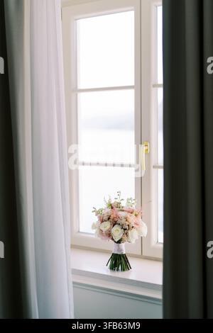 Bouquet de mariée sur une fenêtre lumineuse Banque D'Images