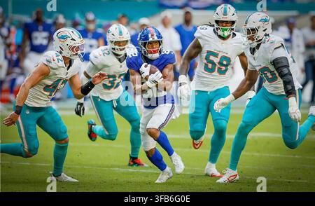 Miami Gardens, États-Unis. 22 août 2026. Le linebacker des Miami Dolphins Jackson Woodard (42), le defensive back Lonnie Johnson (32), les defensive linemen Rodney McGraw (59) et Seth Coleman-Lyles (90) poursuivent le wide receiver des New York Giants Calvin Austin III (82) pendant la première mi-temps d’un match de pré-saison de la National Football League (NFL) au Hard Rock Stadium à Miami Gardens, Fla., le 22 août 2026. Les Giants ont affronté les Dolphins lors de leur troisième match de pré-saison avant la saison régulière 2026. (Photo par Al Diaz/Miami Herald/TNS/Sipa USA) Credit: Sipa USA/Alamy Live News Banque D'Images