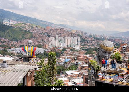 Medellín, Colombie - 15 janvier 2026 : Medellín, Colombie, paysage urbain de la commune 13 mettant en vedette une statue de Jésus emblématique aux couleurs du drapeau colombien et des éléments autochtones Banque D'Images