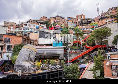 Medellín, Colombie – 15 janvier 2026 : la commune 13 de Medellín présente une art de rue coloré, une grande sculpture de tête indigène et des espaces publics animés Banque D'Images