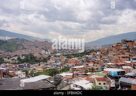 Medellin, Colombie – 15 janvier 2026 : le quartier de Comuna 13 sur une colline montrant des bâtiments urbains bondés avec un fond de montagnes sous un ove Banque D'Images