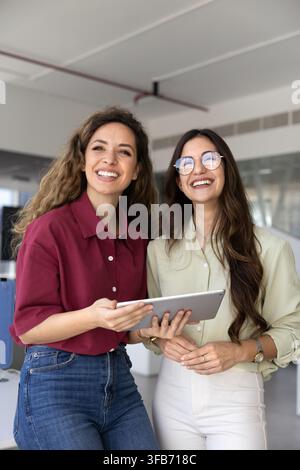 Portrait de deux collègues femmes souriantes participant à une réunion collaborative Banque D'Images
