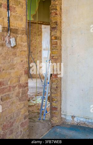 Câblage électrique exposé dans un mur de briques pendant la rénovation du bâtiment Banque D'Images