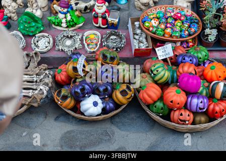 Décorations colorées de la Journée des Morts et de citrouilles d'Halloween exposées sur un marché artisanal traditionnel mexicain. Banque D'Images