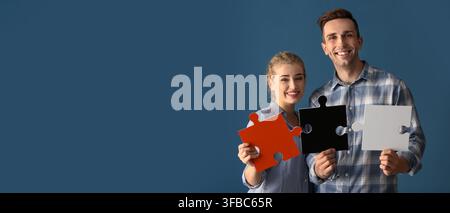 Concept de travail d'équipe et de collaboration, jeune couple tenant des pièces de puzzle, résolution de problème et partenariat sur fond bleu Banque D'Images