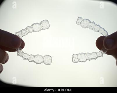Appareils orthodontiques transparents tenus dans les mains pour un traitement orthodontique. Banque D'Images