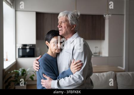 Vieil homme triste embrasse une femme réconfortante. Soutien aux vieux couples, soutien émotionnel, problèmes de santé amoureuse Banque D'Images