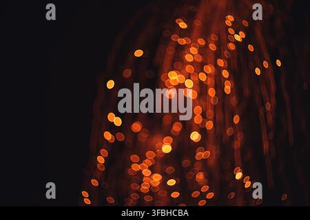 Photographie abstraite à exposition longue dynamique mettant en scène des orbes bokeh dorés lumineux et des traînées de lumière verticales créant une atmosphère de fête avec éclat Banque D'Images
