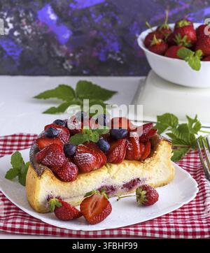 Cheesecake de fromage blanc et de fraises fraîches sur une plaque en céramique blanche Banque D'Images