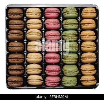 Macarons multicolores dans une boîte en plastique, vue de dessus. Assortiment. Arrière-plan isolé Banque D'Images