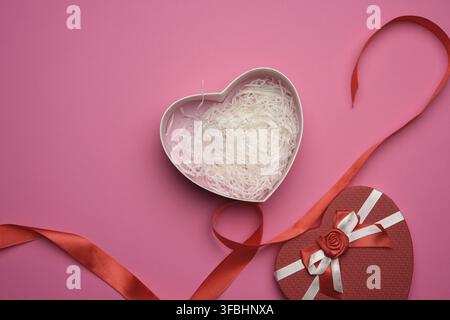 ouvrir une boîte en carton rouge vide sous forme de coeur sur fond rose, vue du dessus Banque D'Images