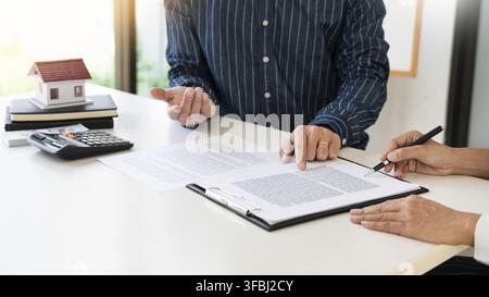 Real estate agents expliquer le document pour les clients qui viennent au contact d'acheter une maison, acheter ou vendre un bien immobilier concept Banque D'Images