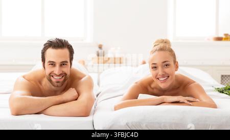 Beau couple couché au spa souriant à l'appareil photo, Panorama Banque D'Images