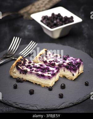 Gâteau de fromage cottage et de bleuets sur fond noir, vue du dessus Banque D'Images