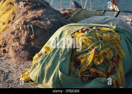 Close-up de filets de pêche commerciaux empilés avec des flotteurs colorés reposant sur un quai du port en Grèce. Banque D'Images