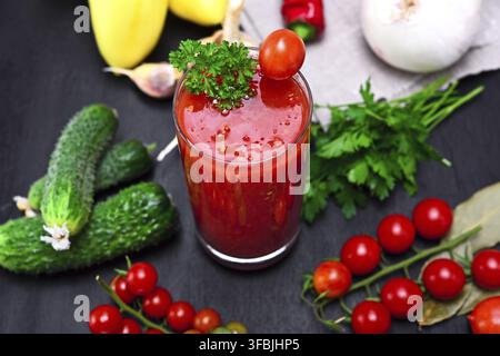 Verre de jus de jus de tomates sur une table avec des légumes, vue du dessus Banque D'Images